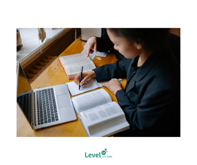 student learning with a laptop, book and a tutor